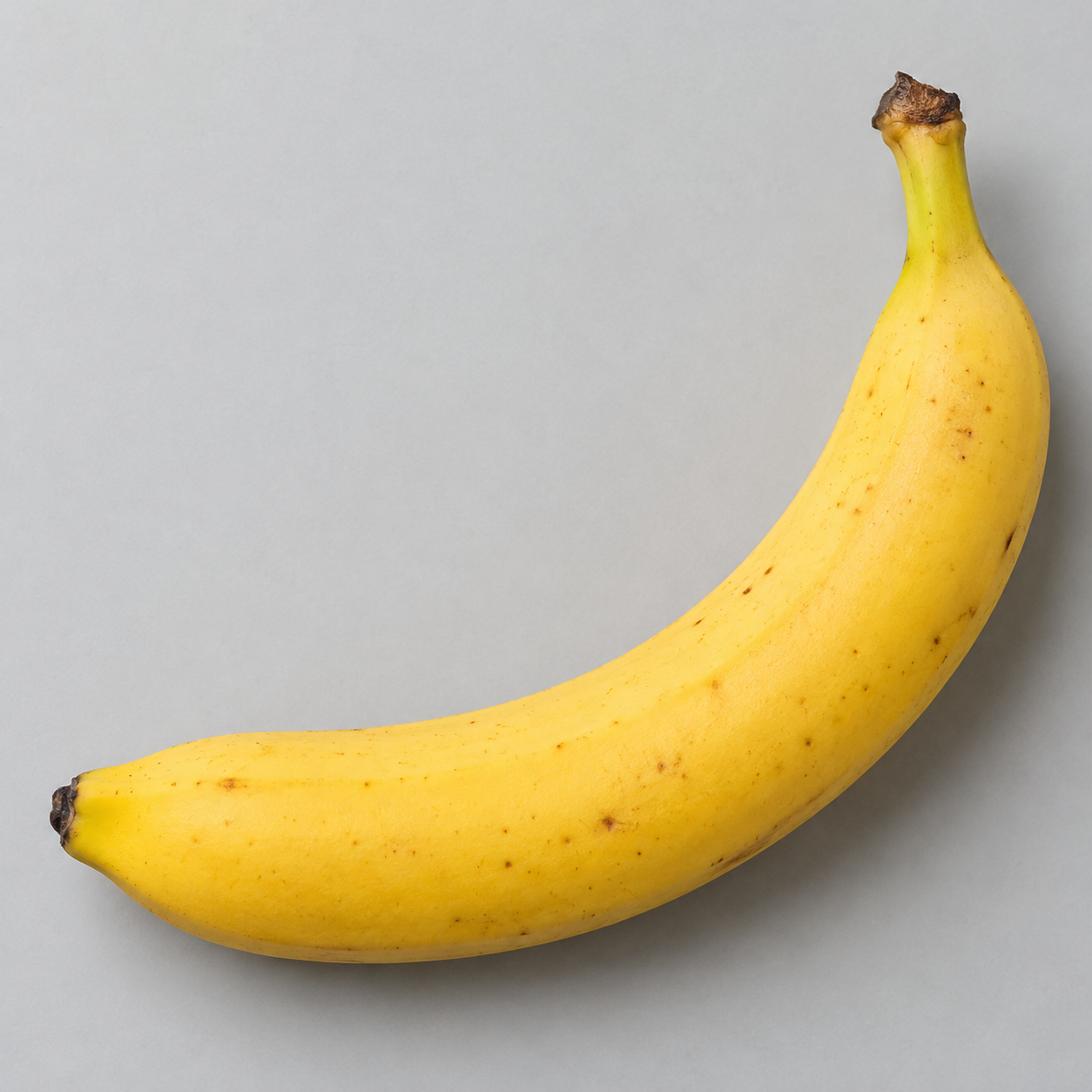 A single yellow banana on a plain background.
